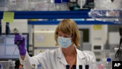 FILE - A lab technician works during research on the coronavirus, at Johnson & Johnson subsidiary Janssen Pharmaceutical in Beerse, Belgium, June 17, 2020.