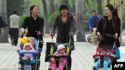 Para ibu mendorong bayi-bayi mereka di dalam kereta di sebuah taman di Beijing. (Foto: Dok)