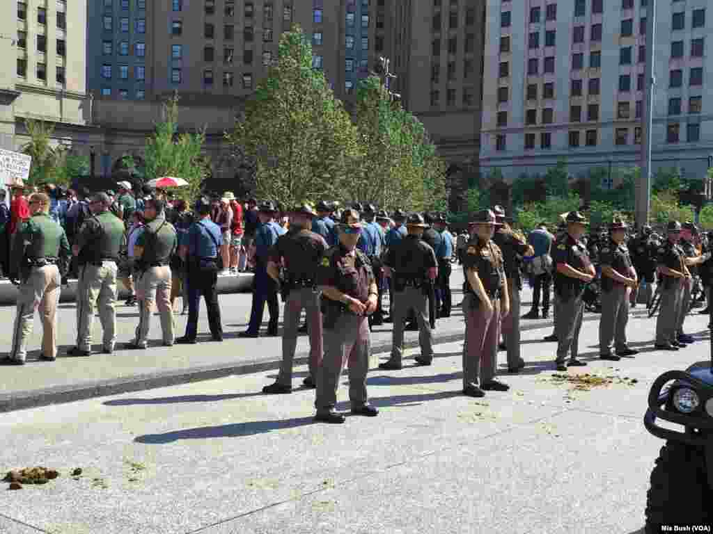 State troopers and police officers stand in lines around the protesters as tensions rose, near the Soldiers and Sailors Monument in Public Square, in Cleveland, July 19, 2016.