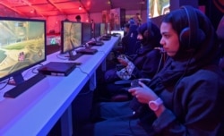 FILE - Saudi youths play at an electronic entertainment house accessible to men and women in Jeddah, Saudi Arabia, May 15, 2019.