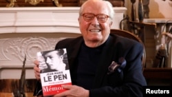 Jean-Marie Le Pen, founder of France's far-right National Front political party, holds his book of memoirs in Montrerout, France, Feb. 27, 2018.