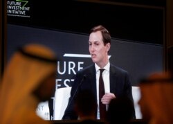 FILE - Participants watch U.S. White House senior adviser Jared Kushner on a screen during his speech in Riyadh, Saudi Arabia, Oct. 29, 2019.