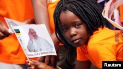 一名莫桑比克小女孩挥舞印有教宗方济各画像的旗子欢迎到访首都马普托的教宗。（2019年9月5日）