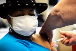Georgette Moon receives a COVID-19 vaccine at the county health department in Tuskegee, Ala., Monday, Jan. 25, 2021. (AP Photo/Jay Reeves)