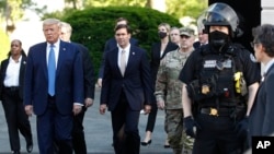 FILE - President Donald Trump departs the White House to walk to St. John's Church in Washington, June 1, 2020. Defense Secretary Mark Esper and General Mark Milley are to Trump's right. (AP Photo/Patrick Semansky, File)