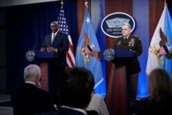Secretary of Defense Lloyd Austin, left, answers a question during a briefing with Joint Chiefs Chairman Gen. Mark Milley at the Pentagon in Washington, Sept. 1, 2021, about the end of the war in Afghanistan.
