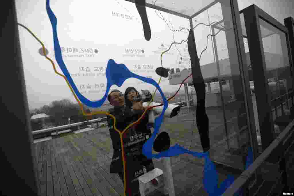 Sepasang warga melihat peta zona demiliterisasi yang memisahkan kedua Korea, di paviliun Imjingak di Paju, utara Seoul (5/4).