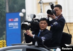 Members of North Korean media take images as the motorcade of North Korea's leader Kim Jong Un rides past the Opera House, after the second U.S.-North Korea summit in Hanoi, Vietnam, Feb. 28, 2019.