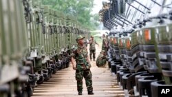 In this file photo taken on June 23, 2010, A Cambodian army soldier looks at Chinese military vehicles displayed before a handover ceremony at a military airbase in Phnom Penh, Cambodia.