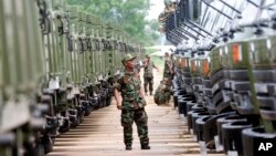 FILE PHOTO - A Cambodian army soldier looks at Chinese military vehicles displayed before a handover ceremony at a military airbase in Phnom Penh, Cambodia, Wednesday, June 23, 2010. 