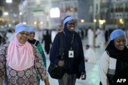 Jemaah haji dari Amerika Serikat, Zainab Nasir (kiri), Shahidah Sharif, Jamila Rashid (kedua dari kiri), dan seorang teman berjalan di Masjidil Haram sebelum mengelilingi Ka'bah untuk menjalankan ibadah haji, 21 September 2015. (Foto: AP)