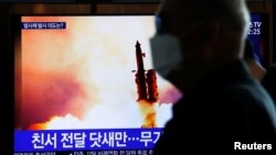 Čovek sa maskom, kojom se štiti od koronavirusa,, posmatra snimak lansiranja neidentifikovane severnokorejske rakete, u Seninu, Južna Koreja, 9. marta 2020.(Foto: Reuters)