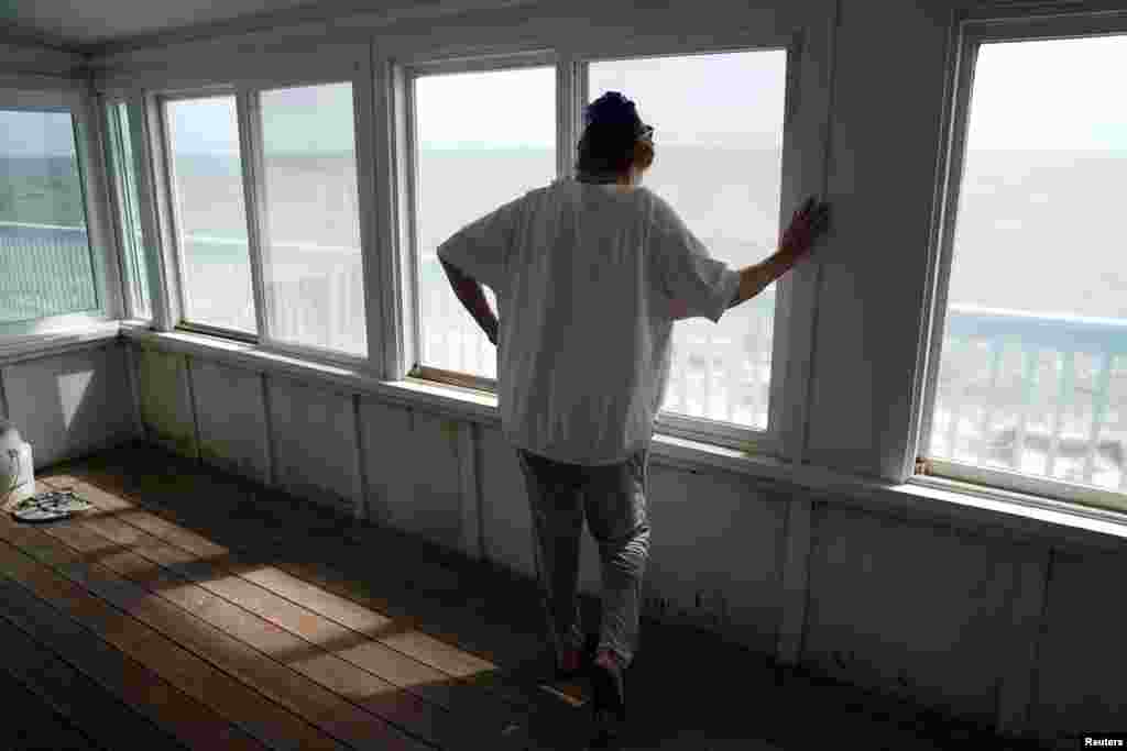 A woman, who refused to give her name, looks out over the water from her porch amid fears she will never see her home again as Hurricane Michael bears down on Alligator Point, Florida, Oct. 9, 2018.