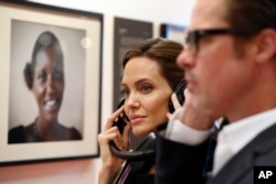 Angelina Jolie and Brad Pitt listen to victims' testimonies at a summit to end sexual violence in conflict, in London, June 12, 2014.