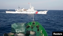 FILE - A Chinese Coast Guard (top) is seen near a Vietnam Marine Guard in the South China Sea, about 210 km (130 miles) off shore of Vietnam May 14, 2014. 