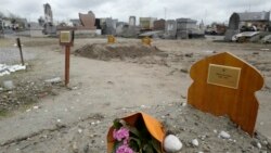FILE- A bouquet of flower lies on the tomb of Yasser Abdallah, from Sudan, who died in an attempt to cross the English Channel in a truck, Sept. 28, 2021, in the Nord Cemetery of Calais, northern France, Nov. 25, 2021.