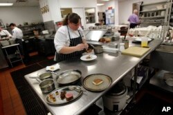 In this Dec. 7, 2012 photo, executive chef Kristin Butterworth prepares a "reveillon" meal at the Grill Room of the Windsor Court Hotel in New Orleans.