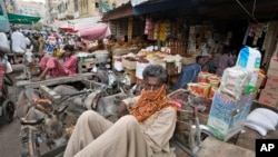 FILE - Laborers wait for work at a market, in Karachi, Pakistan, July 13, 2023. The International Monetary Fund said on March 20, 2024, it reached an agreement with Pakistan's government for the last payment under a $3 billion bailout package.