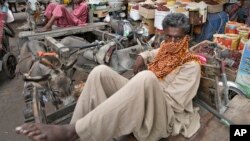 ২০২৩ সালের ১৩ জুলাই পাকিস্তানের করাচিতে একটি বাজারে শ্রমিকরা কাজের জন্য অপেক্ষা করছে। ফাইল ছবি।