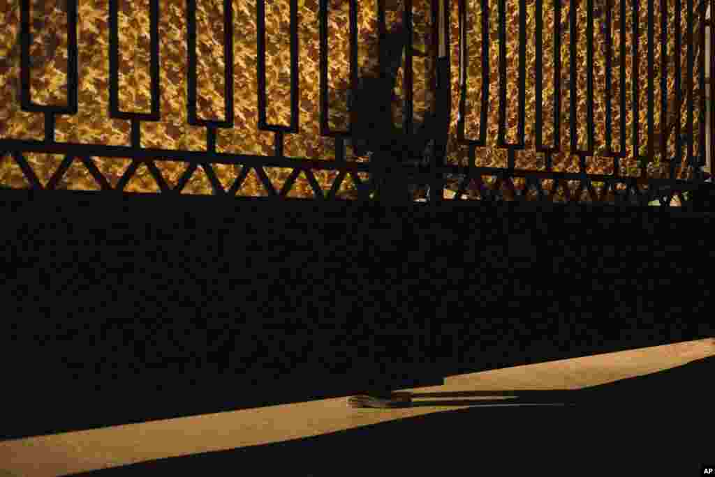 Ukrainian security officer looking through a closed gate as a convoy of refrigerated trucks loaded with bodies of passengers of Malaysia Airlines Flight 17 arrives at a Kharkiv factory in Kharkiv, Aug. 3, 2014.