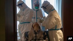 A woman takes a COVID-19 test at a quarantine hotel in Wuhan in central China's Hubei province, March 31, 2020. 