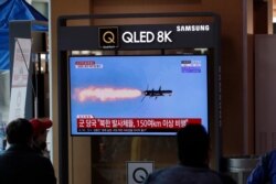 People watch a TV screen showing a news program reporting about North Korea's missiles with a file image at the Seoul Railway Station in Seoul, South Korea, Tuesday, April 14, 2020.
