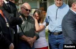 FILE - Pastor Frank Pomeroy, with his wife Sherri, listens at a news conference outside the site of the shooting at his church, the First Baptist Church of Sutherland, Texas, Nov. 6, 2017.