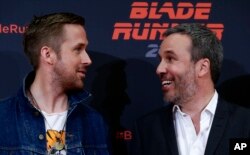 Actor Ryan Gosling, left, and director Denis Villeneuve converse during a photo call to promote the film "Blade Runner 2049" in Barcelona, Spain, June 19, 2017.