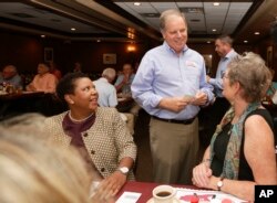 FILE - Democratic Senate nominee Doug Jones, center, talks to supporters, Jennifer L. Greer, right, and Janet Crosby, left, as he campaigns at Niki's West restaurant, Sept. 27, 2017, in Birmingham, Alabama.