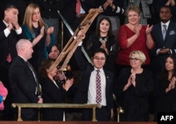 도널드 트럼프 미국 대통령이 30일 국정연설에서 탈북자 지성호 씨를 소개하자 지 씨가 목발을 들어보이고 있다.