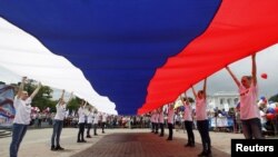 지난 12일 러시아 스타브로폴에서 열린 '러시아의 날' 기념행사에서 청년들이 거대한 국기를 펼치고 있다. (자료사진)