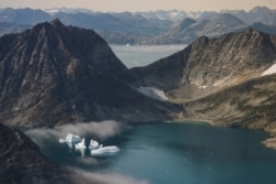 FILE - Icebergs are photographed from the window of an airplane carrying NASA scientists as they fly on a mission to track melting ice in eastern Greenland, Aug. 14, 2019.