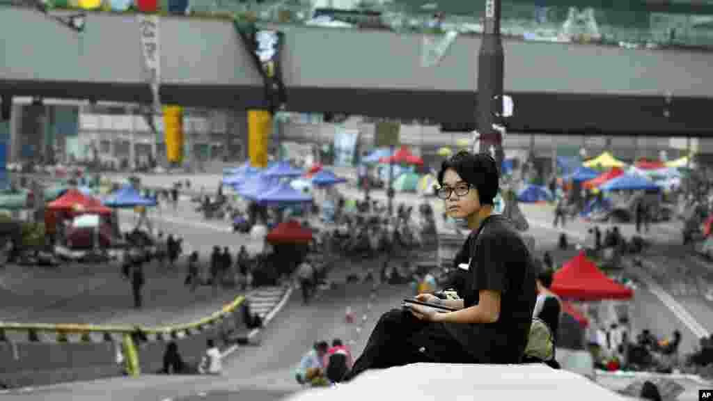 A pro-democracy student protester wakes after a night on the occupied roads of the financial district Hong Kong, Sunday, Oct. 5, 2014.
