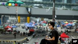 Seorang siswa pro-demokrasi menginap di jalan tempat demo berlangsung di Hong Kong, Minggu, 5 Oktober 2014.