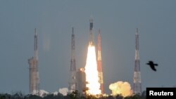 A man at New Delhi's Nehru Planetarium, takes pictures of a web cast of the lift off of Indian Space Research Organization (ISRO)'s Geosynchronous Satellite launch Vehicle (GSLV) MkIII carrying Chandrayaan-2 from Satish Dhawan Space center in Sriharikota