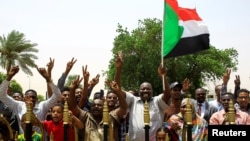 FILE - Sudanese people celebrate the signing of a constitutional declaration between the deputy head of the Sudanese Transitional Military Council, Mohamed Hamdan Dagalo, and Sudan's opposition alliance leader Ahmad al-Rabiah, in Khartoum, Aug. 4, 2019.