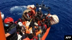 Des 51 migrants, qui dérivaient sur un bateau en bois, sont secourus par des membres de l'ONG française SOS Mediterranée, au large des côtes de l'île de Lampedusa, le 25 juin 2020.