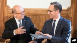 Menteri Luar Negeri Perancis Jean-Yves Le Drian (kiri) dan Menteri Luar Negeri Jerman Heiko Maas, bertukar dokumen di Villa Borsig di Berlin, 7 Mei 2018. 