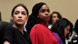 FILE - Rep. Alexandria Ocasio-Cortez, left, and Rep. Ayanna Pressley, D-Mass., center, attend a hearing on Capitol Hill, July 15, 2019.