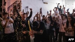 ក្រុម​អ្នក​គាំទ្រ​លទ្ធិប្រជាធិបតេយ្យ (រូប​កណ្តាល) បើក​ដប​ស្រា​ទៅ​ក្រៅ​ស្ថានីយ​បោះឆ្នោត​ដើម្បី​សាទរ​បន្ទាប់​ពី​ក្រុម​គាំទ្រ​រដ្ឋាភិបាល​ក្រុង​ប៉េកាំង​បាន​ចាញ់​ឆ្នោត​សម្រាប់​ការ​បោះឆ្នោត​ក្រុមប្រឹក្សា​ស្រុក នៅ​ក្នុង​ក្រុង​ហុងកុង កាលពី​ថ្ងៃទី២៥ ខែវិច្ឆិកា ឆ្នាំ២០១៩។