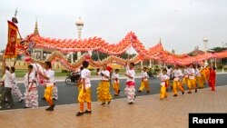 រូបឯកសារ៖ ពលរដ្ឋខ្មែររាំមុងសាយដើម្បីប្រារព្ធពិធីបុណ្យចូលឆ្នាំចិនកាលពីថ្ងៃទី៩ ខែកុម្ភៈ ឆ្នាំ២០១៣។ (រូបថត Reuters)