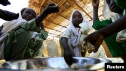 Pengungsi anak-anak usia sekolah makan dari mangkuk yang sama di kamp Abushouk di Al Fasher, Darfur Utara, Sudan, 17 Nov 2015.