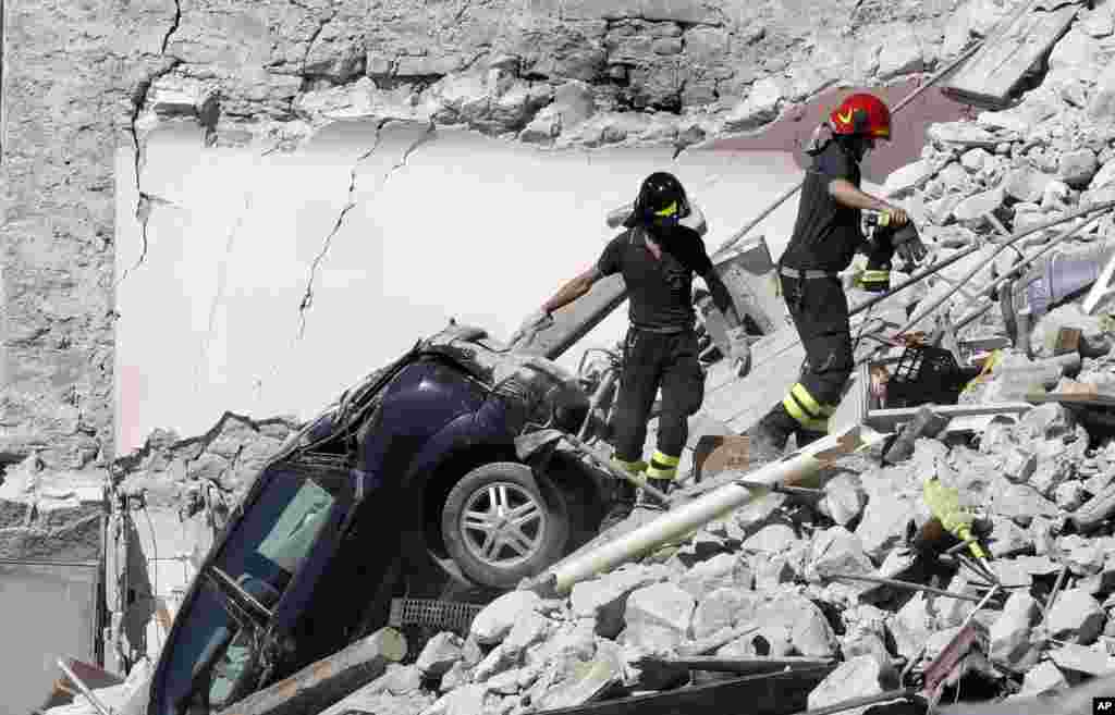 Rescuers make their way through destroyed houses following Wednesday&#39;s earthquake in Pescara Del Tronto, Italy, Aug. 25, 2016.