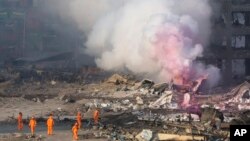 13일 대형 폭발 사고가 발생한 중국 톈진에서 소방관들이 방화복을 입고 현장을 수색하고 있다.