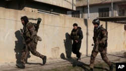 Iraq's special forces troops advance during a battle against Islamic State militants in the eastern side of Mosul, Iraq, Jan. 16, 2017. 