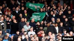 FILE - Crystal Palace fans mock the opposing team with flags of Saudi Arabia before a match between Crystal Palace and Newcastle United, in Selhurst Park, London, Oct. 23, 2021. (Action Images via Reuters)