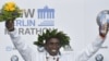 Eliud Kipchoge célèbre son trophée sur le podium lors de la cérémonie de remise des prix, après avoir remporté le marathon de Berlin, établissant un nouveau record mondial le 16 septembre 2018.