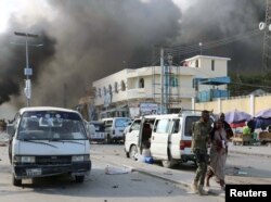 A Somali government soldier evacuates a woman, injured during an explosion, in KM4 street in the Hodan district of Mogadishu, Somalia, Oct. 14, 2017.