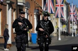 Armed police officers patrol on the streets in Windsor, England, May 17, 2018. Britain's Prince Harry and Meghan Markle will marry in Windsor on Saturday.