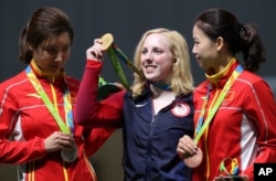 Virginia Thrasher, center, of the United States holds her gold medal for the Women's 10m Air Rifle competition during the award ceremony at the 2016 Summer Olympics in Rio de Janeiro, Brazil, Aug. 6, 2016.